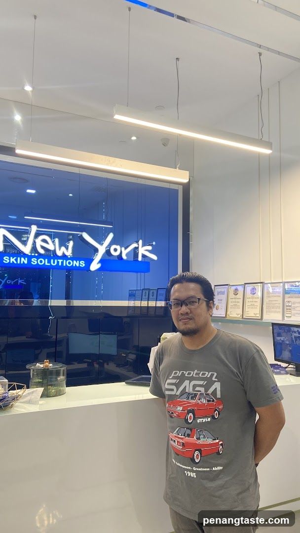 Man in Proton Saga T-Shirt at Reception Desk