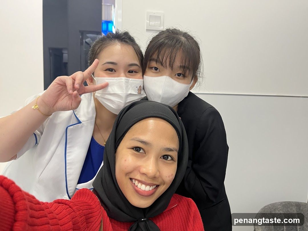 Three women in medical or professional attire taking a selfie indoors