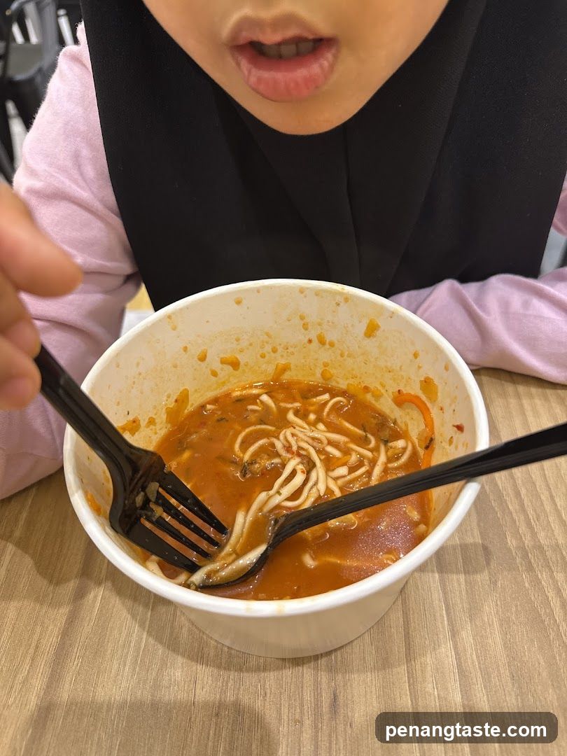 Person eating noodles in a bowl