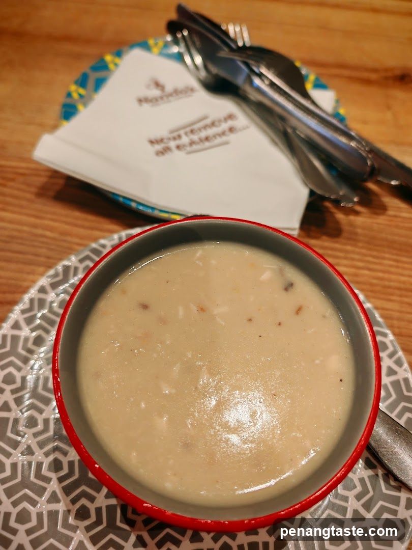 Bowl of creamy soup with cutlery and napkin