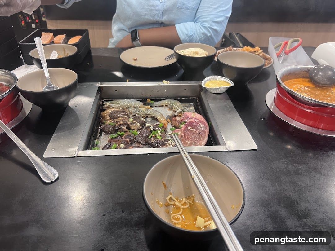 Table with Korean BBQ and Side Dishes