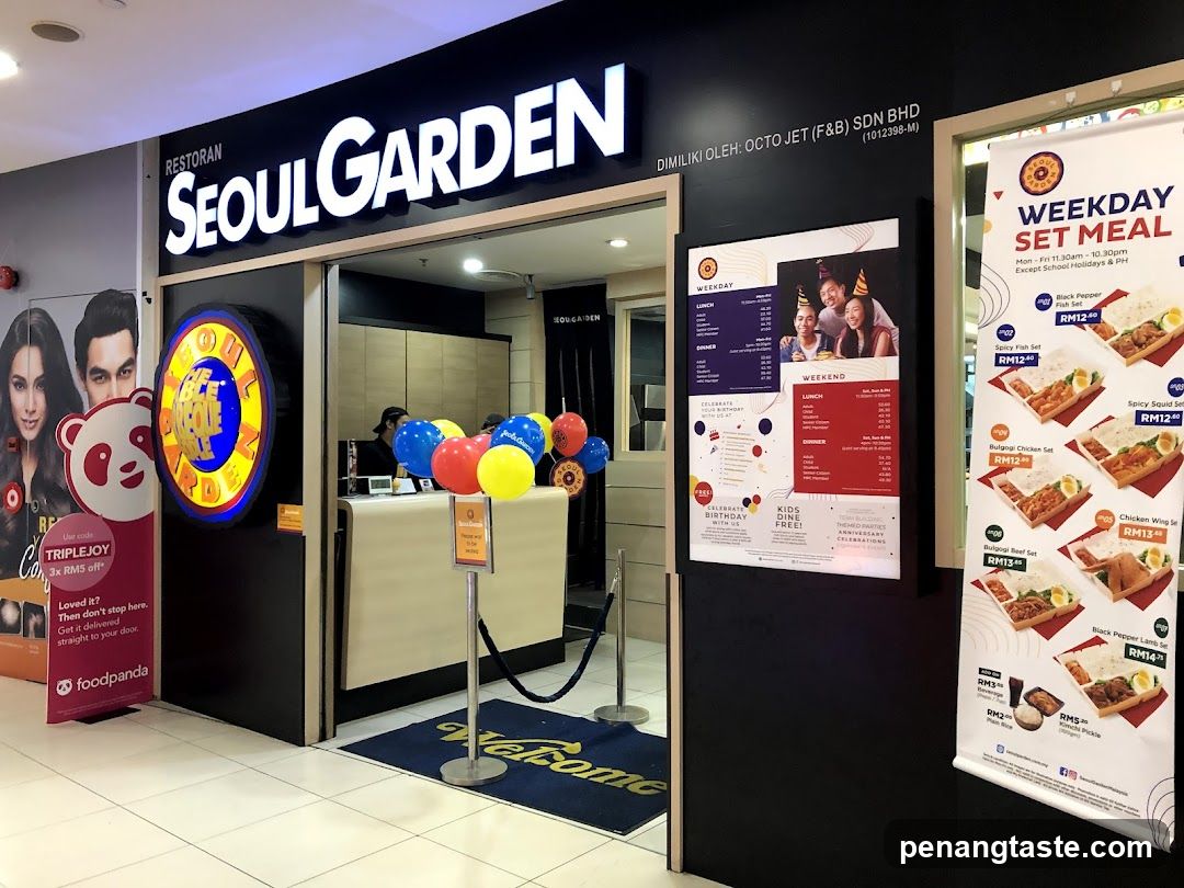 A storefront of Seoul Garden restaurant with visible signage, entrance door, and promotional posters on either side. Balloons are placed near the entrance.